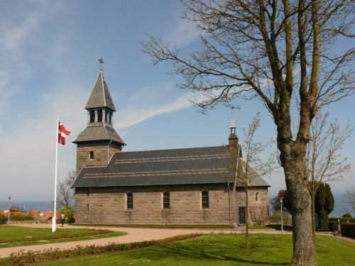 Stary, zadbany kościół. Obok flaga, która jest wszędzie eksponowana. Nie to co u nas - tylko od święta... #bornholm #dania #kościół #zabytkowy #flaga